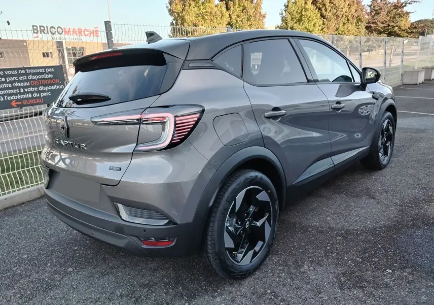 Vue 3/4 arrière droite du Renault Captur E-Tech gris Cassiopée avec toit noir et jantes noires biton.