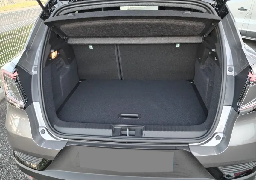 Coffre ouvert vu de l'arrière d'un Renault Captur gris Cassiopée avec toit noir, montrant l'espace de chargement vide.