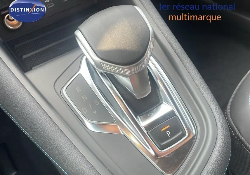 Le levier de vitesses automatique du Renault Captur E-Tech hybride 2025, avec finition noire et surpiqûres bleues.