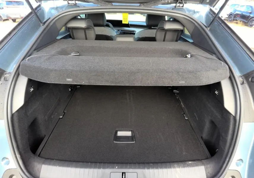 Coffre ouvert vu de l'arrière du Peugeot 3008 bleu clair, montrant l'espace de chargement et la plage arrière.