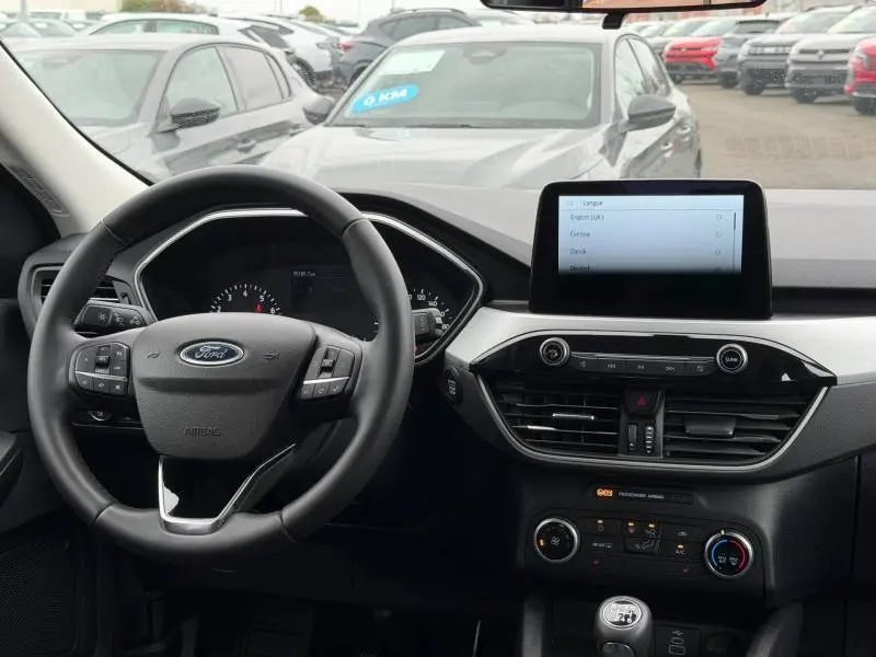Vue intérieure du tableau de bord du Ford Kuga 2024 1.5 EcoBoost Titanium, avec volant multifonction et écran tactile central.