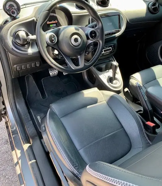 Intérieur côté conducteur du Smart Fortwo électrique gris 2019, volant multifonction et console centrale moderne.