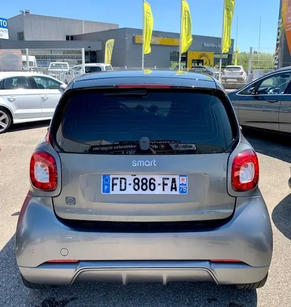 Vue arrière d'une Smart Fortwo Coupé électrique gris 2019, avec vitres teintées et logo Brabus Style visible.