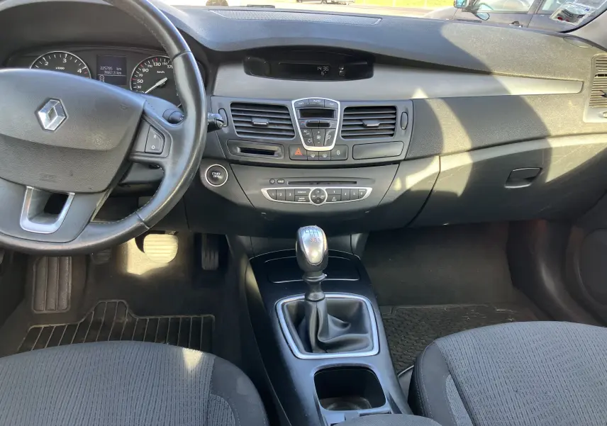 Intérieur noir de Renault Laguna 2008, vue centrale sur tableau de bord et levier de vitesses manuel en tissu.