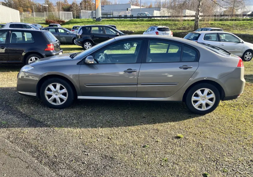 Profil côté gauche d'une Renault Laguna gris vert de 2008, berline 5 portes avec jantes alliage et vitres teintées.