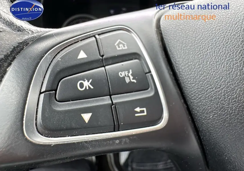 Gros plan sur les commandes au volant de la Mercedes Classe C 180 d business gris alu de 2017, côté gauche.