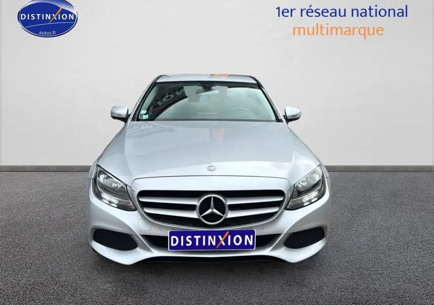 Vue frontale d'une Mercedes Classe C 180 d business gris alu avec calandre étoilée et phares LED visibles.