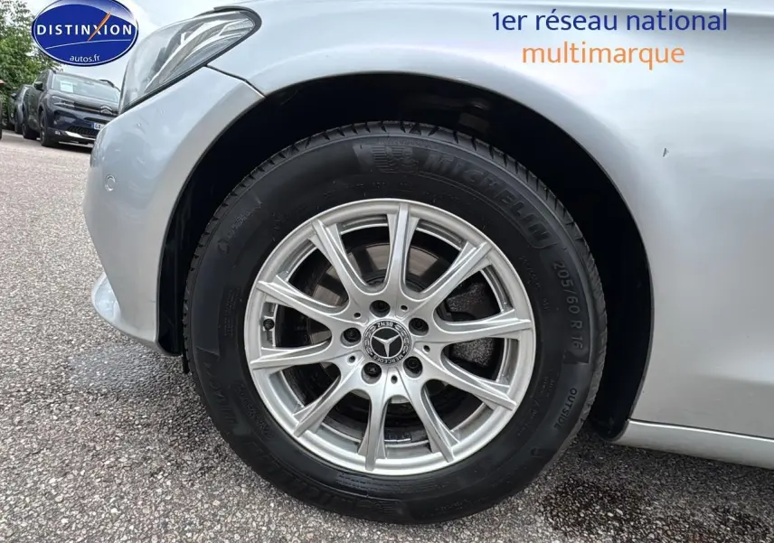 Gros plan sur la roue avant gauche d'une Mercedes Classe C 180 d business gris alu, jante alliage 16 pouces.