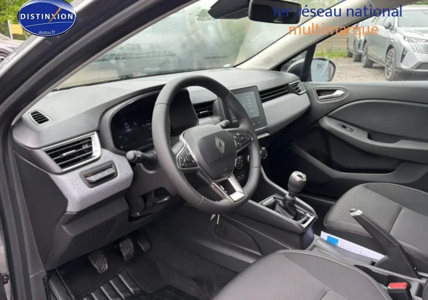 Vue intérieure côté conducteur de la Renault Clio V 1.0 TCe 90 gris schiste avec volant multifonction et boîte manuelle.
