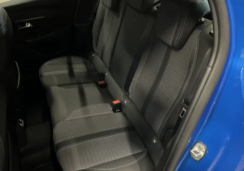 Vue intérieure côté droit des sièges arrière en tissu gris et cuir noir de la Peugeot 208 Bleu Vertigo 2020, porte ouverte.