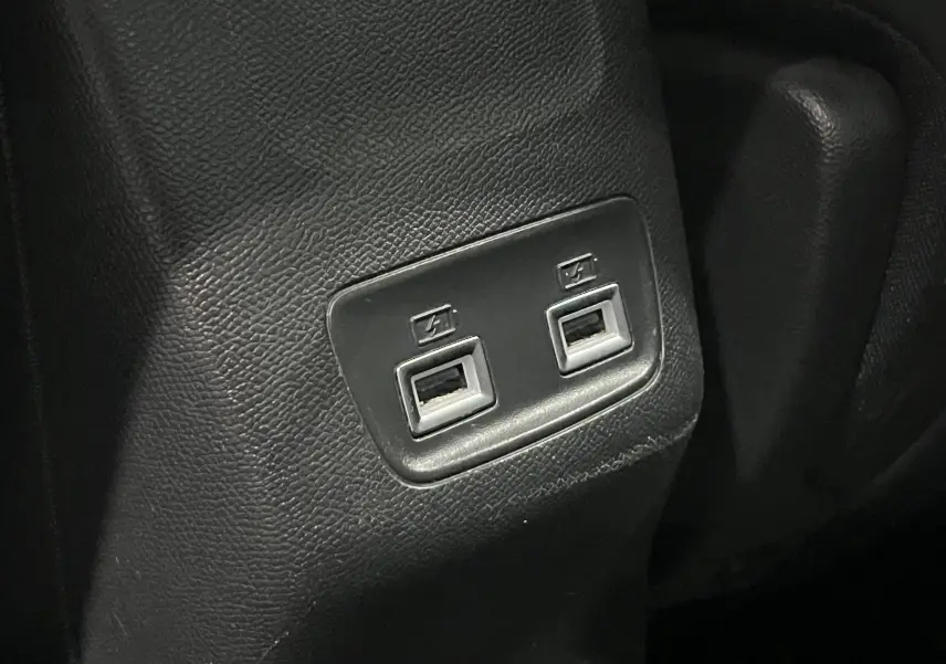 Gros plan sur deux ports USB intégrés dans la console arrière en plastique noir du Peugeot 208 Bleu Vertigo 2020.