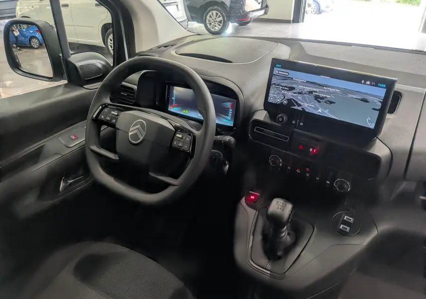 Vue intérieure côté conducteur du Citroën Berlingo blanc 2025, avec tableau de bord numérique et écran tactile central.