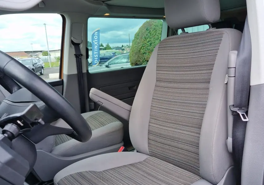 Vue intérieure côté conducteur du Volkswagen California 2021 Cooper bronze, siège avant en tissu rayé gris et beige.