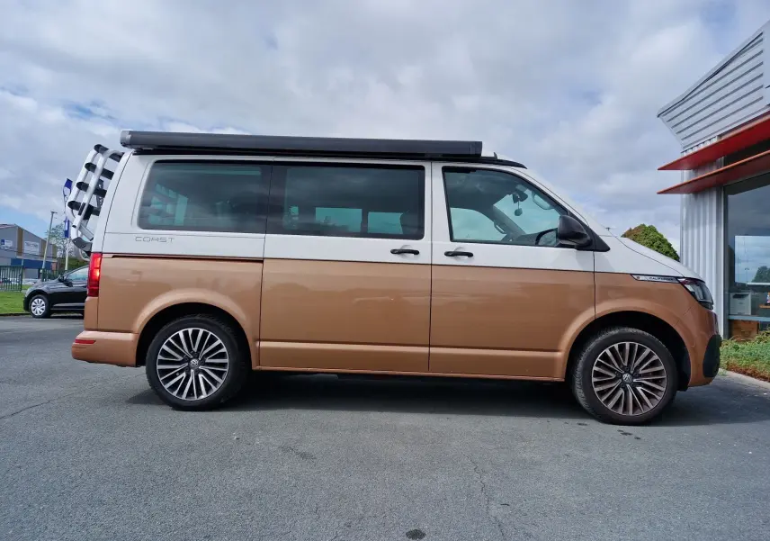 Profil côté droit du Volkswagen California 2.0 TDi 150 ch Coast 2021 en Cooper bronze avec toit relevable et porte-vélos arrière.