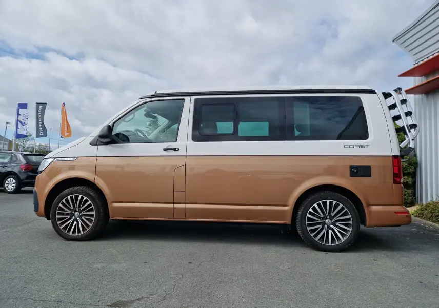 Profil côté gauche d'un Volkswagen California 2.0 TDi 150 ch Coast 2021 en Cooper bronze avec toit blanc et porte-vélos arrière.