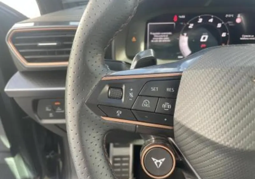 Gros plan sur le volant perforé et les commandes du tableau de bord digital du CUPRA Leon 2025.