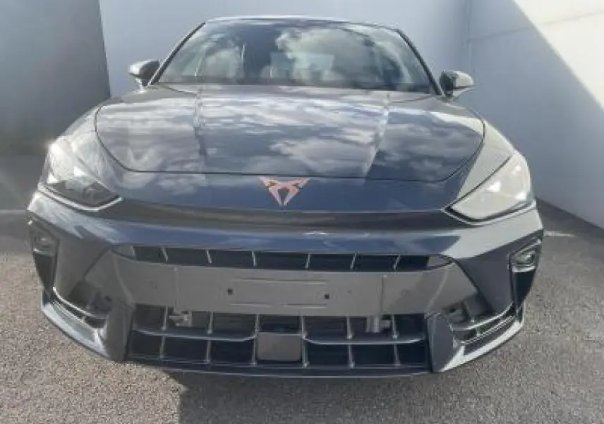 Vue avant d'une CUPRA Leon 2025 gris magnetic metal avec logo CUPRA cuivré et phares LED triangulaires.