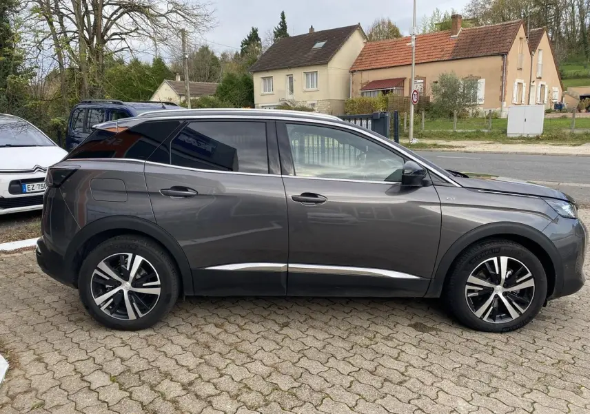 Profil côté gauche d'un Peugeot 3008 gris foncé 2023 avec jantes alliage et coques de rétroviseurs noires.