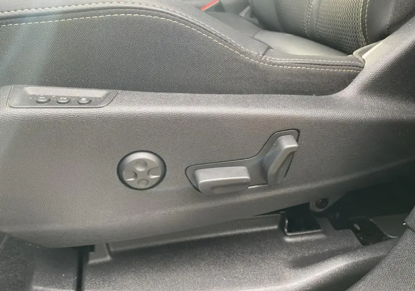 Gros plan sur les commandes de réglage électrique du siège conducteur noir du Peugeot 3008 Hybrid 2023.