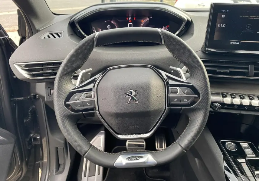 Volant GT en cuir noir du Peugeot 3008 2023 hybride, avec tableau de bord numérique et console centrale moderne.