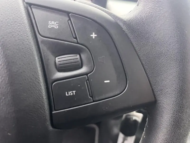 Gros plan sur les commandes noires au volant du côté gauche d’un Citroën C4 Cactus Gris Platinium 2020.