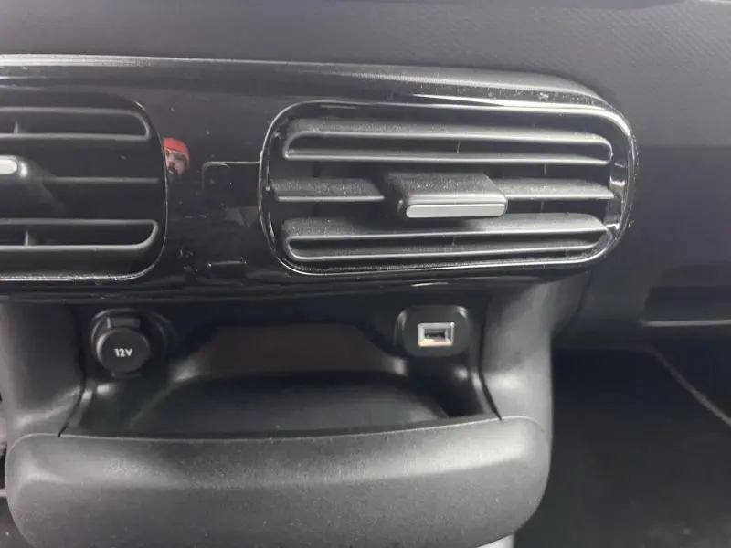 Détail de la console centrale d'une Citroën C4 Cactus 2020 gris Platinium, avec prise USB et prise 12V sous les aérateurs noirs.