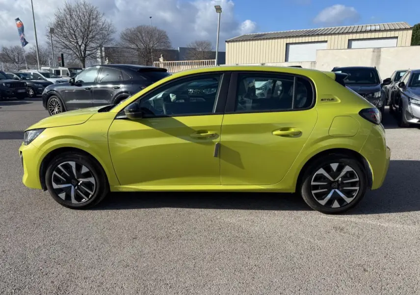Profil droit d’une Peugeot 208 jaune 2025 Style avec jantes 16 pouces et badge distinctif sur l’aile arrière.