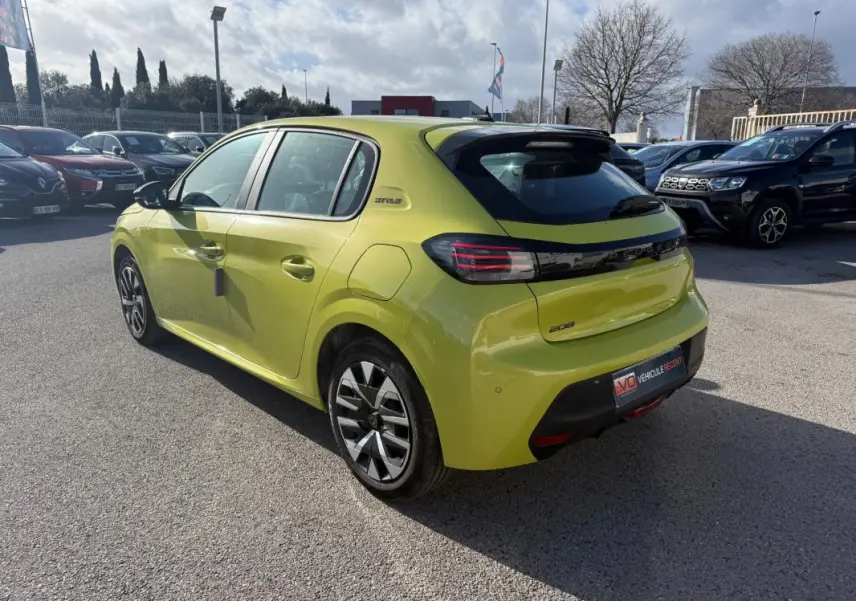 Peugeot 208 jaune vue 3/4 arrière droit, avec jantes 16 pouces et badge Style sur le côté.