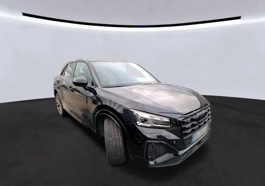 Audi Q2 noir vue 3/4 avant droit, mettant en valeur la calandre distinctive et les jantes alliage.