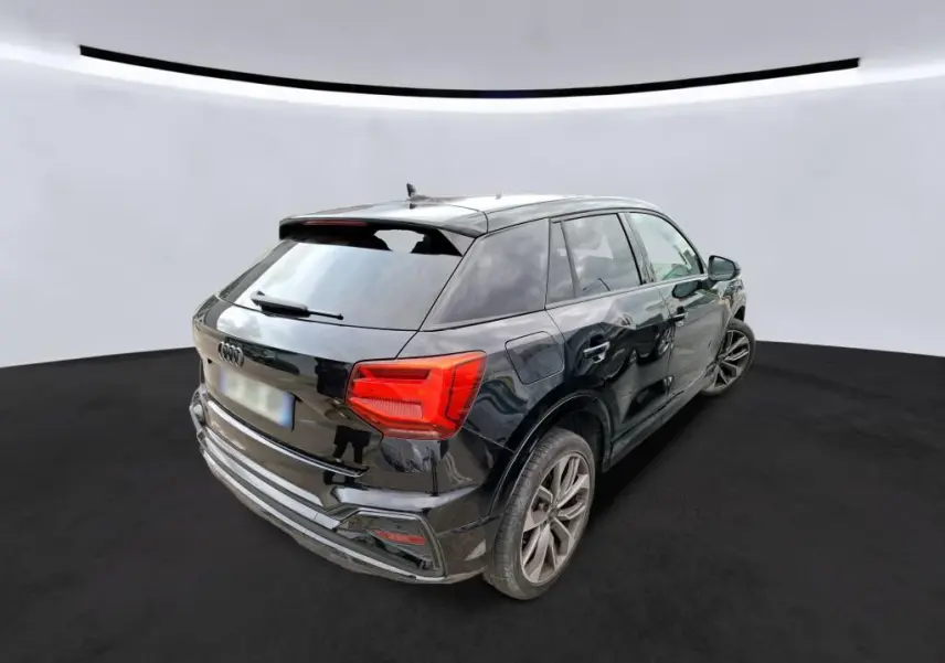 Audi Q2 noire vue 3/4 arrière droit, avec jantes alliage et feux arrière LED distinctifs.