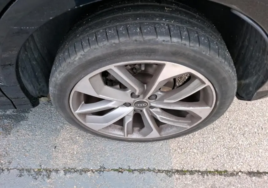 Gros plan sur la jante alu 19 pouces en Y de couleur grise d'un Audi Q2 noir, vue côté droit.