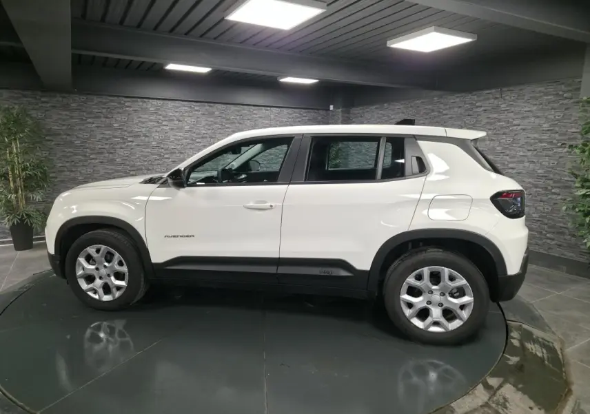 Vue de profil côté gauche du Jeep Avenger blanc 2025 avec jantes alliage et détails noirs contrastants.