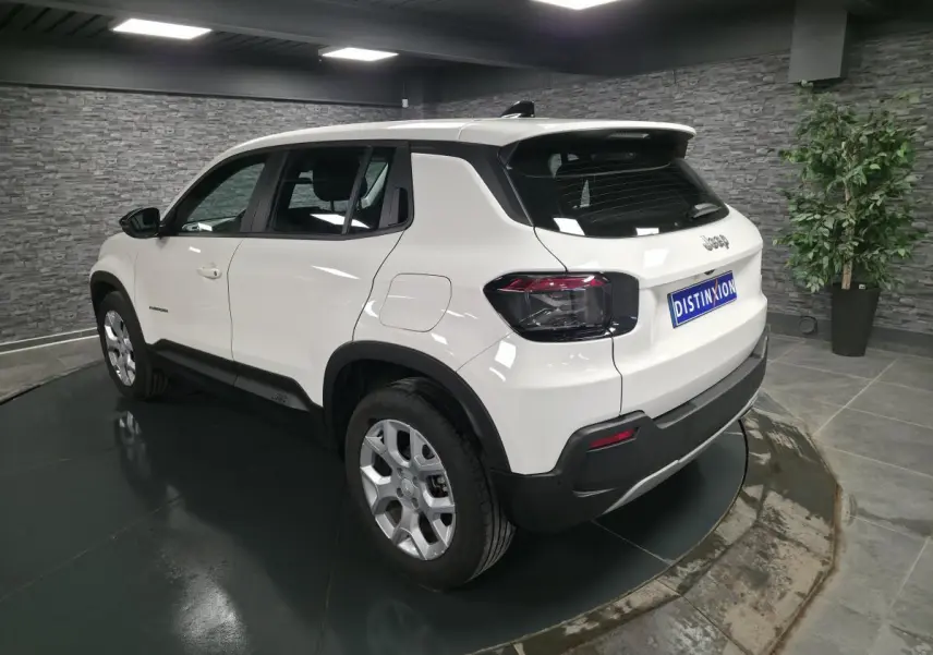 Jeep Avenger blanc en vue 3/4 arrière droit, avec jantes alliage 17 pouces et feux arrière foncés.