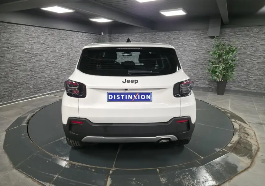 Vue arrière d'un Jeep Avenger blanc 2025 avec feux arrière noirs et hayon électrique mains libres.