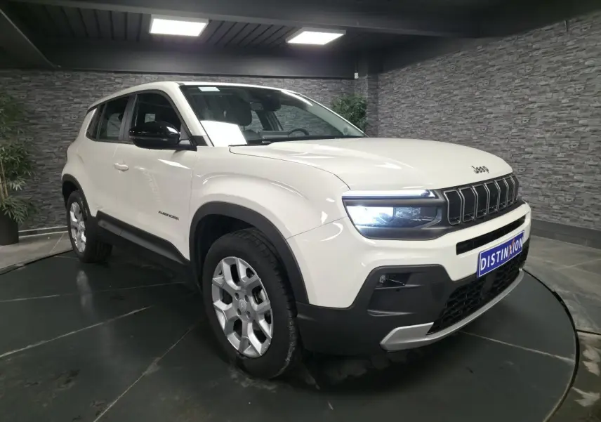 Jeep Avenger blanc en 3/4 avant droit, avec calandre noire distinctive et jantes alliage 17 pouces.