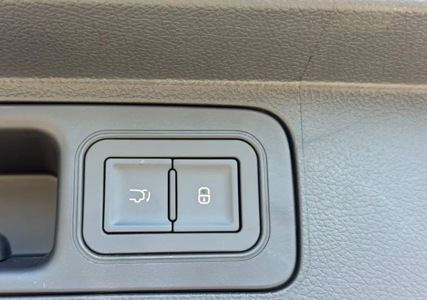 Gros plan sur les boutons d'ouverture du coffre et de verrouillage dans l'habitacle gris foncé du BYD SEAL U 1.5 DM-i.