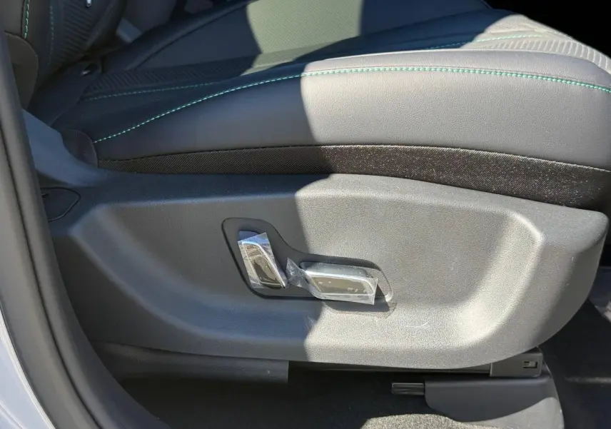 Détail du réglage électrique du siège conducteur noir avec surpiqûres vertes dans un BYD SEAL U 2026.