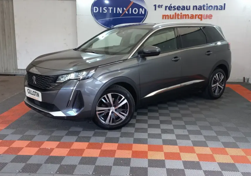 Peugeot 5008 gris foncé vue 3/4 avant droit, avec jantes alliage et toit noir en showroom.