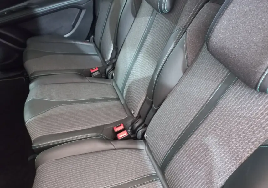 Vue rapprochée des sièges arrière gris foncé du Peugeot 5008, montrant les finitions tissu et cuir avec surpiqûres contrastantes.