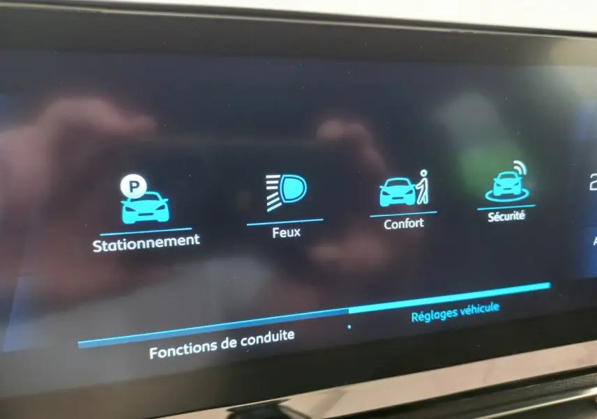 Écran tactile du tableau de bord du Peugeot 5008 2021 affichant les options stationnement, feux, confort et sécurité.