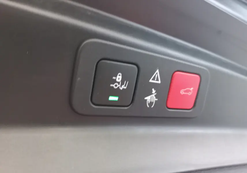 Gros plan sur les boutons de commande du hayon et des sièges arrière dans un Peugeot 5008 gris foncé de 2021.