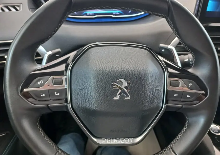 Volant cuir noir de Peugeot 5008 PureTech 130 2021 vu de face avec commandes intégrées et logo lion central.