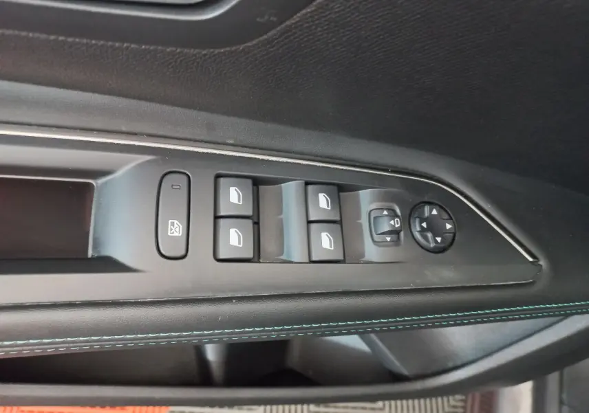 Panneau de porte côté conducteur noir avec commandes électriques des vitres et réglage des rétroviseurs sur Peugeot 5008 gris foncé.