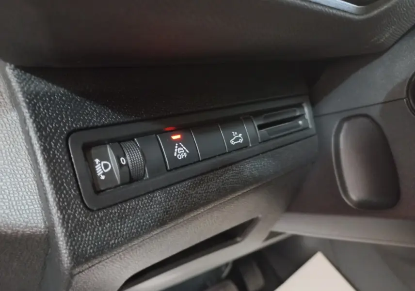 Gros plan sur les commandes d'éclairage et assistance au freinage du tableau de bord du Peugeot 5008 gris foncé, côté conducteur.