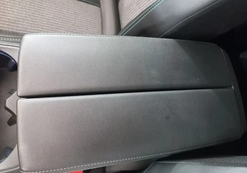 Accoudoir central en cuir noir avec surpiqûres contrastantes dans l'habitacle du Peugeot 5008 Gris foncé.