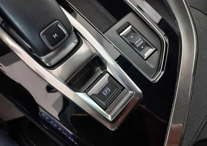 Gros plan sur la console centrale noire du Peugeot 5008 2021 avec bouton frein électrique et sélection mode de conduite.
