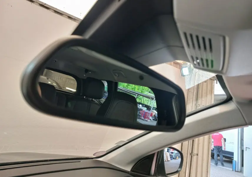 Rétroviseur intérieur montrant les sièges arrière noirs du Peugeot 5008 gris foncé, vue côté conducteur.