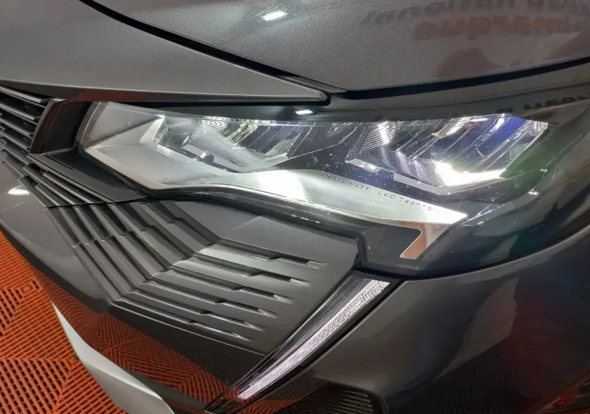 Gros plan sur le phare avant droit LED et la calandre du Peugeot 5008 gris foncé, version 2021 Allure Pack.