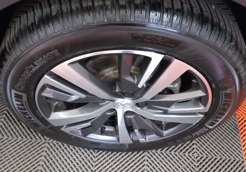 Gros plan sur la jante alliage et pneu Michelin d'un Peugeot 5008 gris foncé, vue latérale rapprochée.