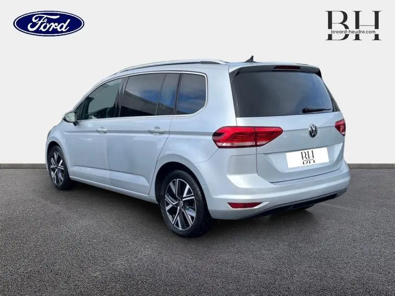 Vue 3/4 arrière droite d'un Volkswagen Touran 2021 Reflet d'Argent Métallisée avec vitres teintées et jantes alliage.